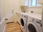 View of laundry room with utility sink, quartz counters and new washer & dryer.