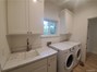 Laundry room with quartz counters, utility sink, & new washer & dryer.
