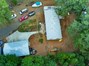 Drone Shot of half of the one acre property can see Main 3/2 House and 3 Car Shop.