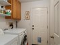 Indoor laundry room with storage shelving and access to the 3 car garage.