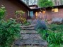 Front Yard beautifully displays an ancient Indian Grinding Stone to the right of the handsome stone walkway to the front door.
