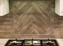 Gas cooktop has a pull-out exhast fan above the Herringbone tile work.