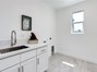 Laundry room with a sink , storage cabinets and window for natural light