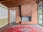 Original corner brick fireplace and built-ins on left wall