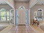 Large entry way with high ceilings and transoms on the doors.