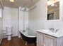 Downstairs full bathroom features a clawfoot tub and wainscotting.