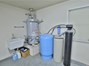 The very large Hot Water Heater has the Well Tank, the Water Softener, and the Salt Tank, nearby.