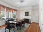 Formal Dining Room with fireplace, custom drapes and wallpaper and stained-glass swinging doors leading to the kitchen