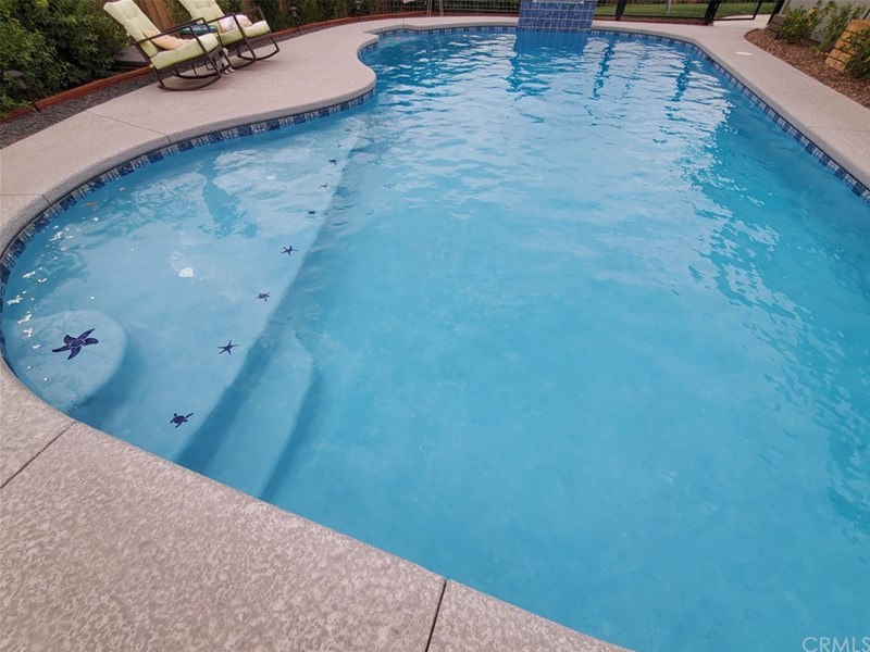 View of built-in pool with umbrella holder at shallow end.