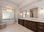 Elegant primary bath boasts spa quality free standing soaking tub...